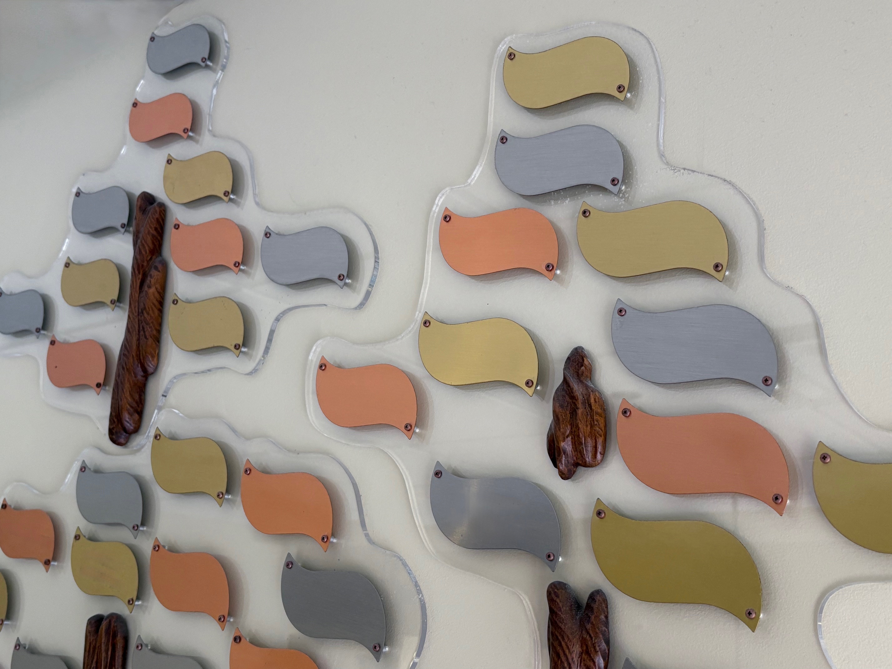 Tree shaped wall art with leaf shaped plaques in silver, gold, and bronze