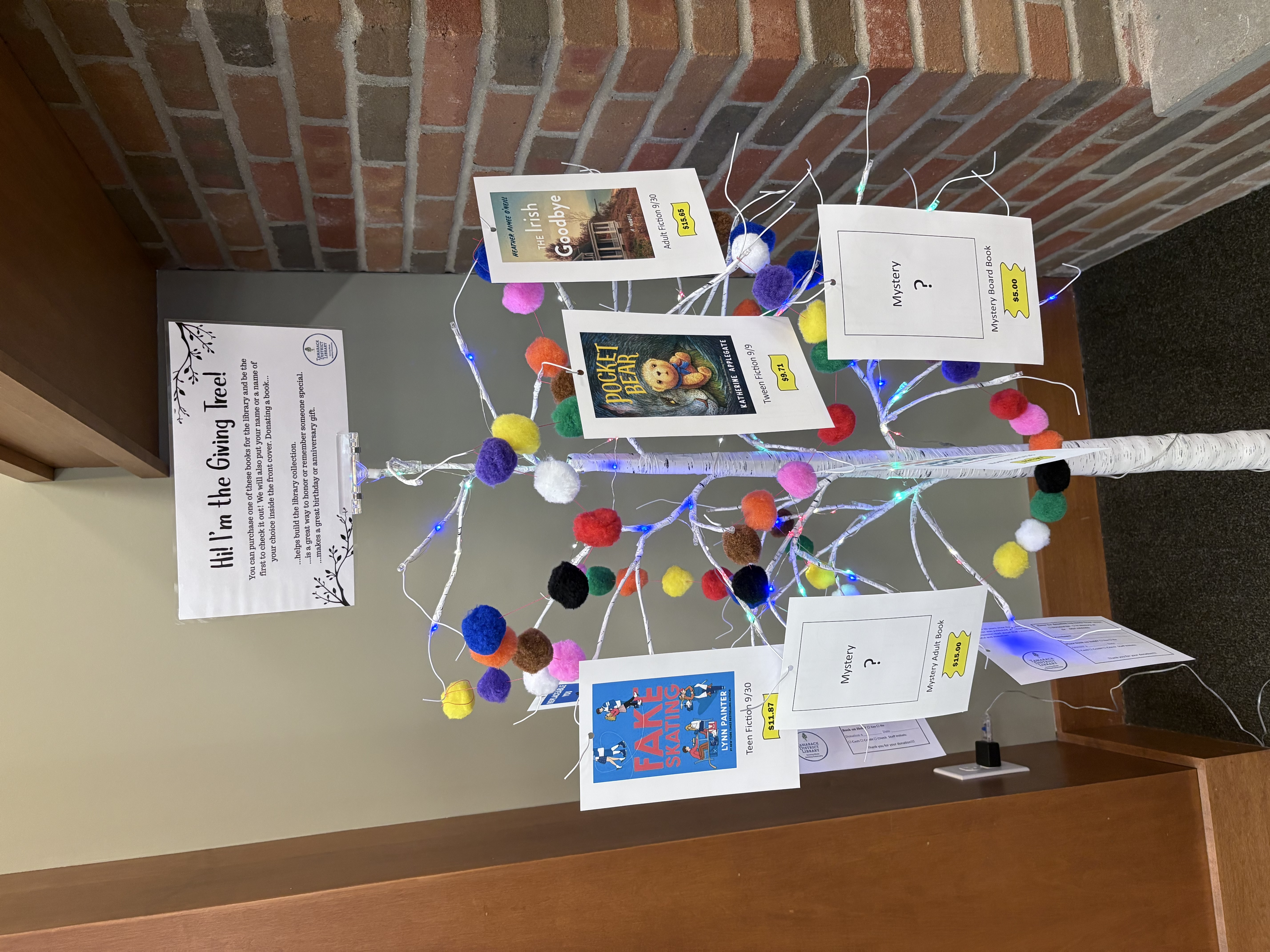 Artificial birch tree with pictures of books hanging on the branches