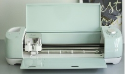 mint colored Cricut machine sitting on top of a desk