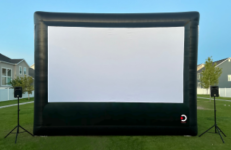 Outdoor Movie Screen with speakers on a green lawn