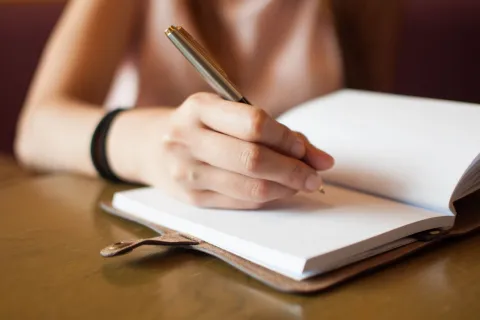 a woman writing in a notebook