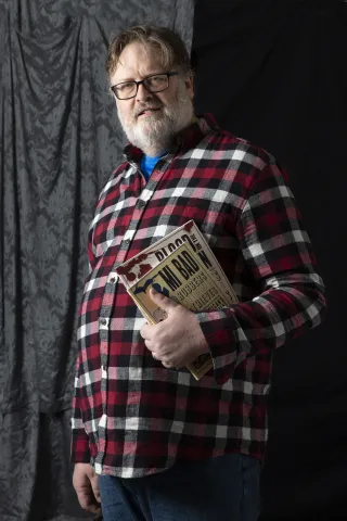 Author Presenter Tom Carr holding a book